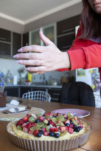 Portrait of woman preparing a fruit cake at home
