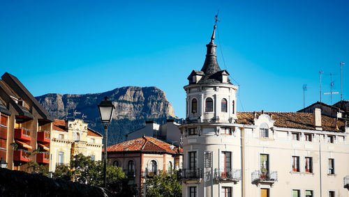 Buildings in town against clear blue sky