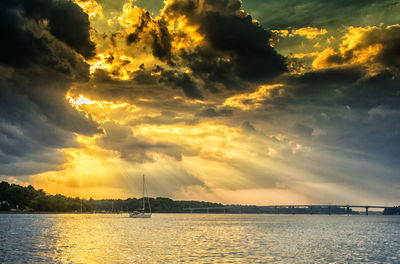 Scenic view of sea against cloudy sky during sunset