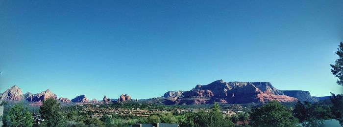 Panoramic view of rocks against clear blue sky