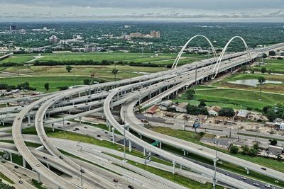 High angle view of highway by cityscape against sky