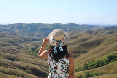 Midsection of woman standing on mountain against sky