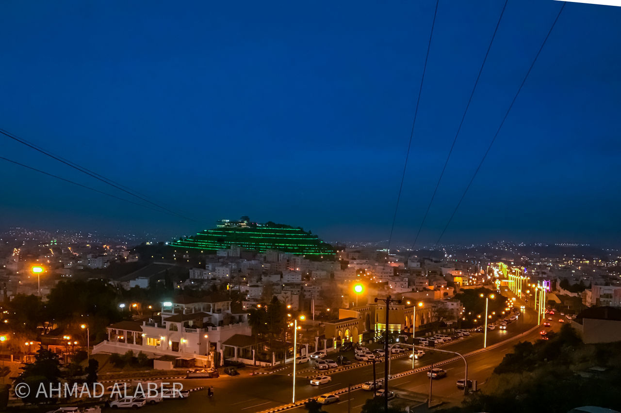 HIGH ANGLE VIEW OF ILLUMINATED BUILDINGS AT NIGHT