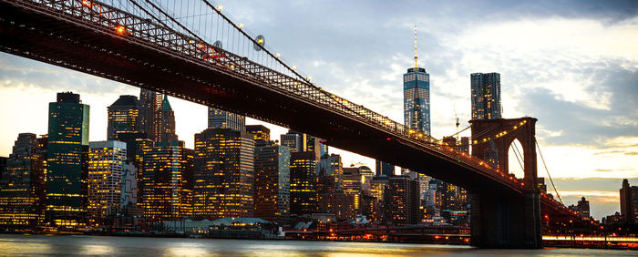 Manhattan bridge over east river and illuminated buildings at night view in new york city, usa.