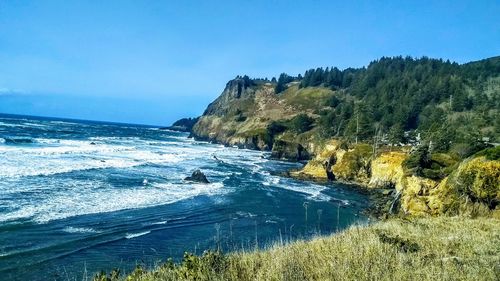 Scenic view of beach against blue sky