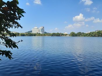 View of buildings by lake against sky