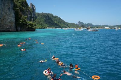 People enjoying in sea against sky