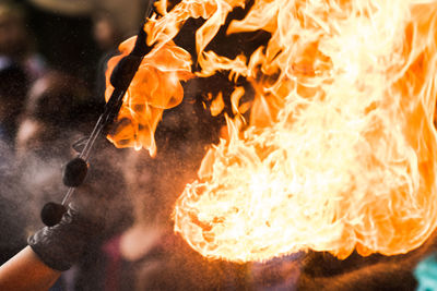 Close-up of hand holding fire against blurred background