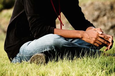 Low section of man sitting on field