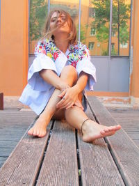 Full length of woman sitting outdoors