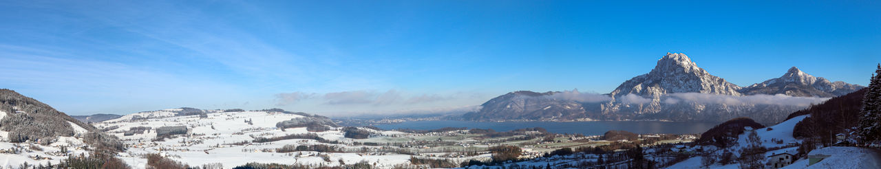 Panoramic view of snowcapped mountains against blue sky