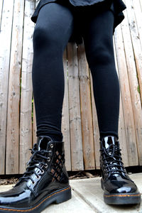 Low section of woman standing on wooden floor