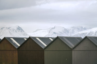 Houses against snowcapped mountains against sky