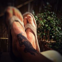 Low section of woman relaxing on tiled floor