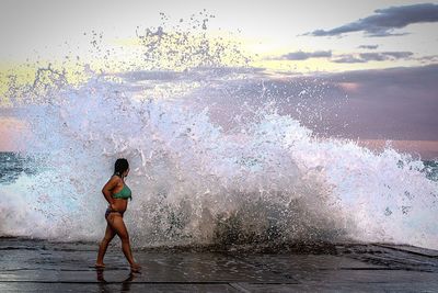 Full length of woman standing in water against sky