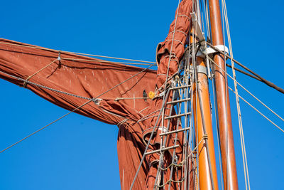 Low angle view of crane against clear blue sky