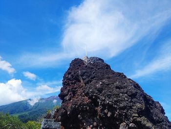 Low angle view of rocks on mountain against sky