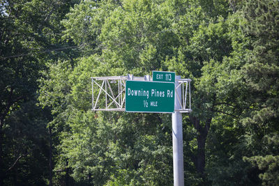 Low angle view of road sign against trees