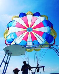 Low angle view of people on hot air balloon against sky