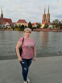 Portrait of woman standing against building