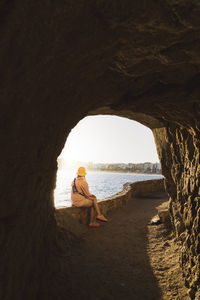 Rear view of woman sitting at beach