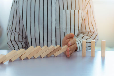 Midsection of woman playing block removal game at table