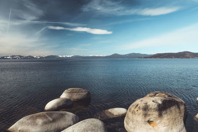 Wide angle shot of lake tahoe with snowy mountain range in background