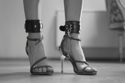 Low section of woman wearing fetish belt and high heels
