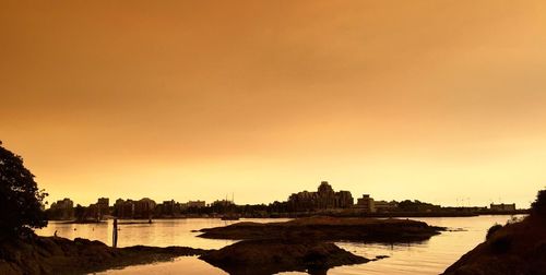 Scenic view of river against orange sky