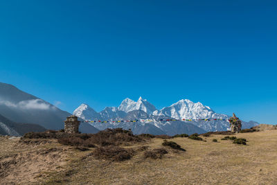 Scenic view of snowcapped mountains against clear blue sky