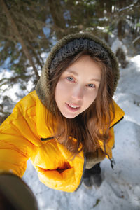Selfie portrait full length caucasian young woman makes selfie on camera wide angle in winter forest