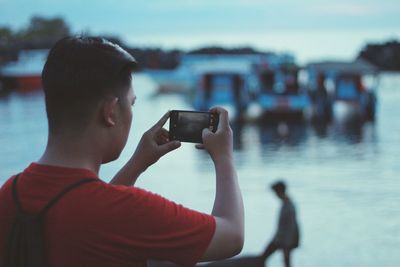 Young woman photographing through smart phone