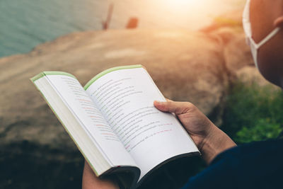Midsection of person reading book