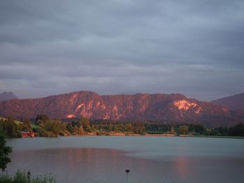 Scenic view of lake by mountains against sky