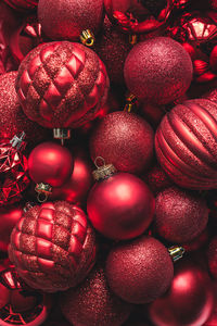 High angle close up of a variety of red christmas ball ornaments.