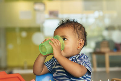 Portrait of cute boy drinking outdoors