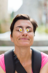 Portrait of woman with flowers on eyes