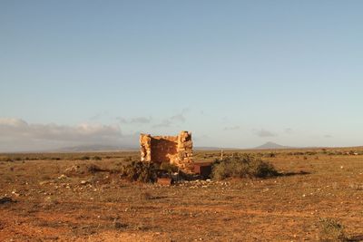 Abandoned structure on field against sky