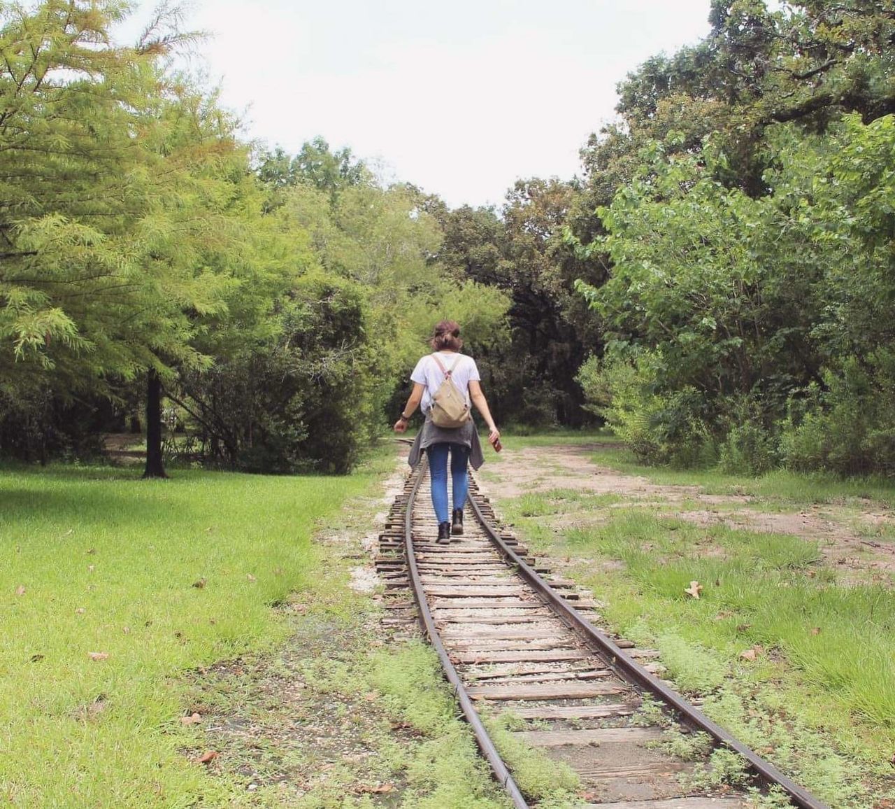 FULL LENGTH REAR VIEW OF MAN WALKING ON DIRT ROAD