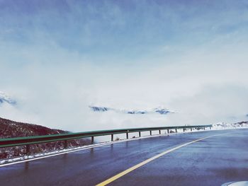 Road sign on highway against sky