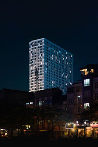 Low angle view of illuminated buildings against blue sky