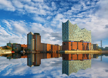 Reflection of buildings in city against sky