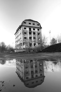 Reflection of building in lake against sky