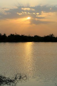 Scenic view of lake against orange sky