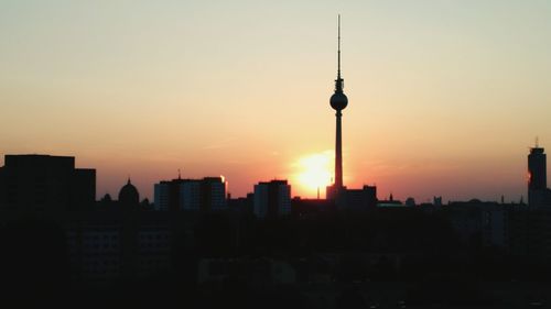 Silhouette of city against sky during sunset