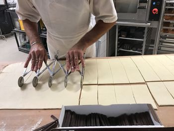 Midsection of baker cutting dough