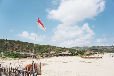 Flag on beach against sky