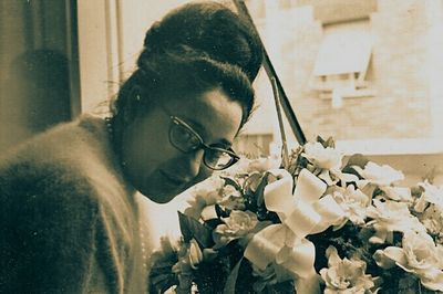 Close-up portrait of young woman with red flowers