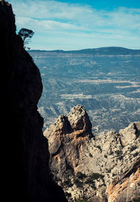 Rock formations on landscape against cloudy sky