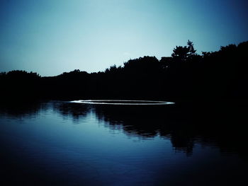 Scenic view of lake against clear sky during sunset